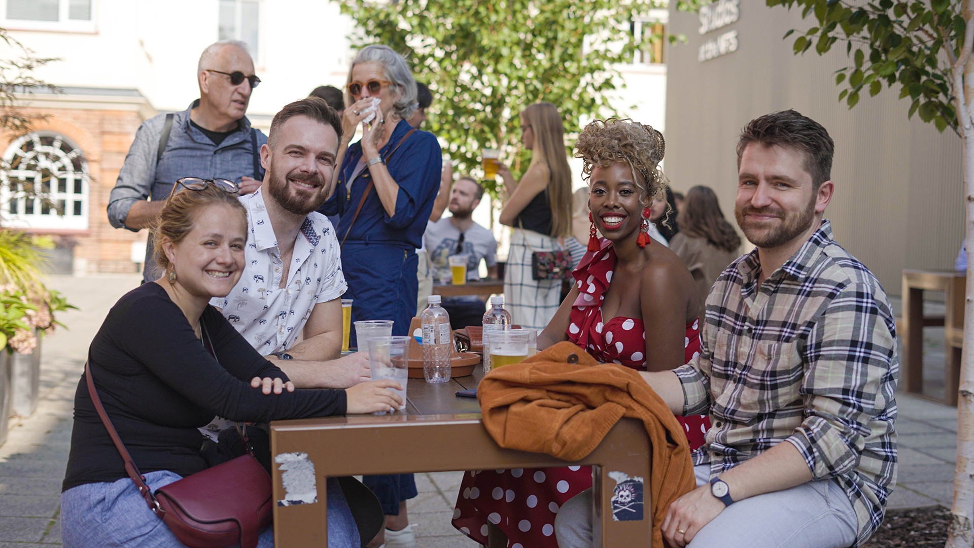 Students sitting round table having photo taken