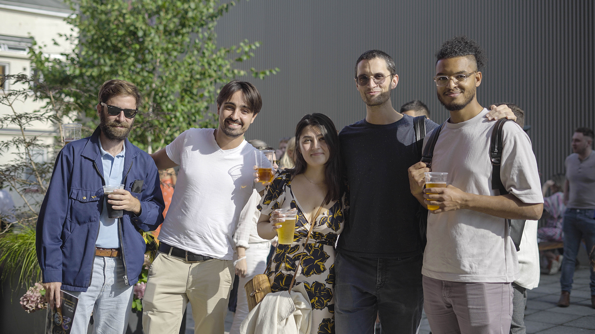 Students with drinks posing for camera outside