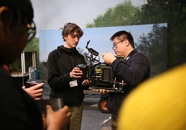 Participant with tutor on set learning about cameras