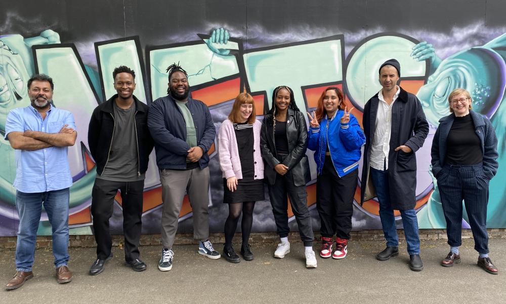 group of people stood in front of graffiti wall