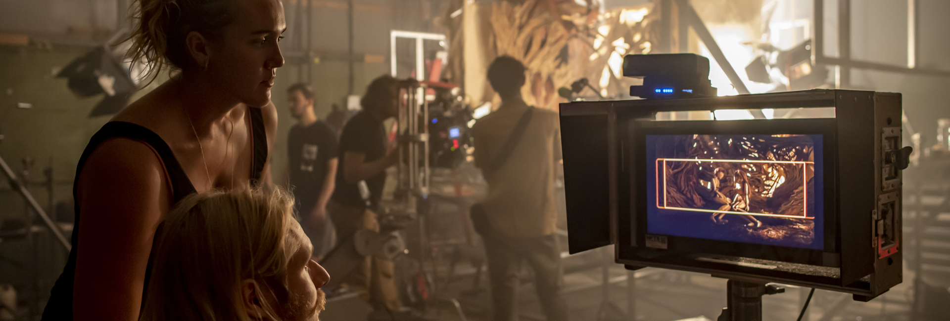 Students watching monitor while filming on set